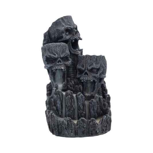 Three grimacing skulls look as if they are carved into a mountain.